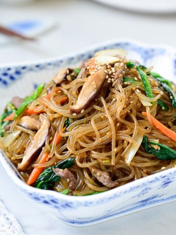 Stir-fried glass noodles with beef and vegetables in a square bowl