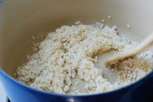 Stir-frying rice in sesame oil for porridge