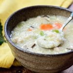 Korean porridge made with leftover turkey in a brown ceramic bowl