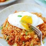 Kimchi fried rice in a large plate with a sunny side up egg