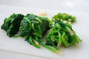 Squeezed spinach being cut into bite sizes