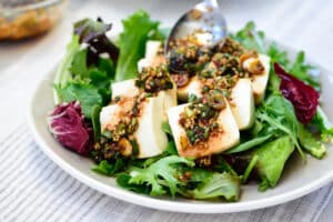 sliced tofu on a bed of spring mix with a soy based sauce drizzled over