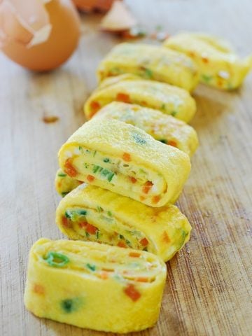 Korean rolled omelette with chopped carrot and scallion on a cutting board