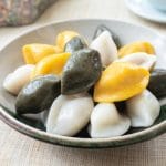 Korean half-moon shape rice cakes in yellow, green and white colors