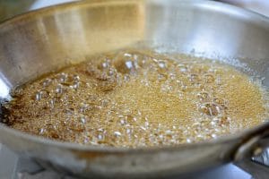 Making syrup for sesame crunch in a pan
