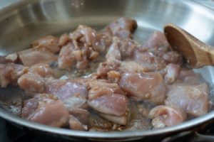 cooking chicken pieces in a pan
