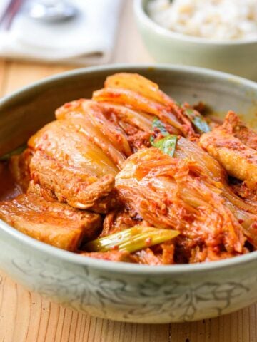 Braised kimchi with pork served in a large bowl with a bowl of rice