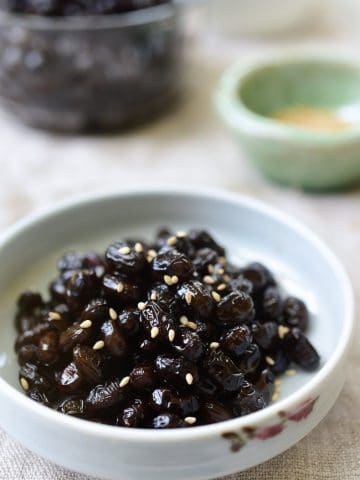 Soy braised soybean side dish garnished with optional sesame seeds