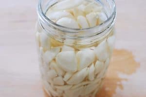 Korean pickled garlic in a jar with a vinegar brine