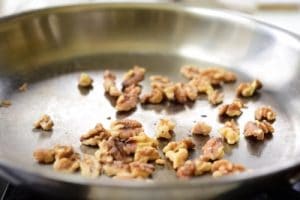 stir-frying walnuts in a pan