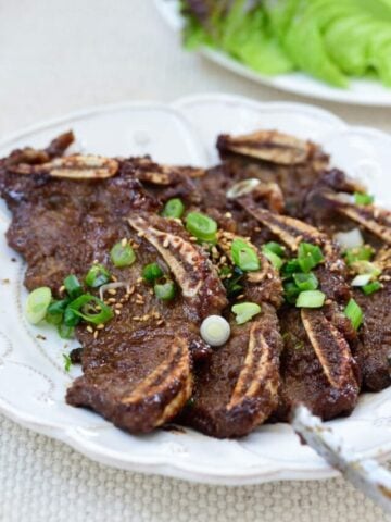 Korean beef short ribs in a plate with lettuce in the background