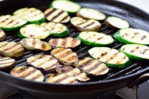 grilling eggplant and zucchini slices in a grill pan