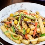 Korean finger size rice cakes stir-fried with beef, mushrooms, carrot, zucchini slices