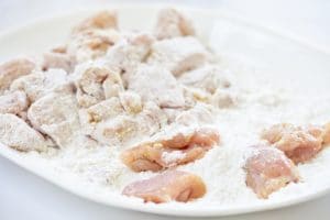 Dredging chicken pieces in starch