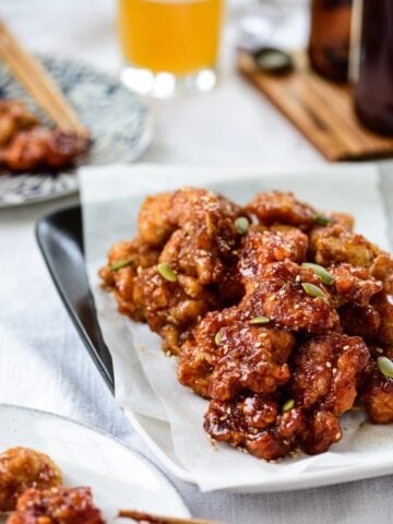 Bite sized Korean fried chicken in a sticky, sweet sauce served with beer