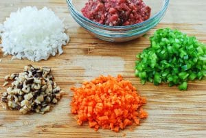 Chopped vegetables and beef on a cutting board for fried rice