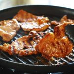 Korean soybean paste marinated pork being grilled on a grill pan