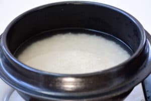 Rice being cooked in a black pot