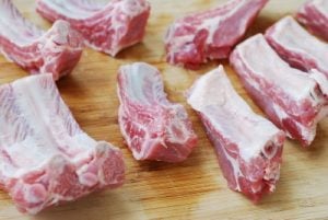 separating pork ribs on a cutting board