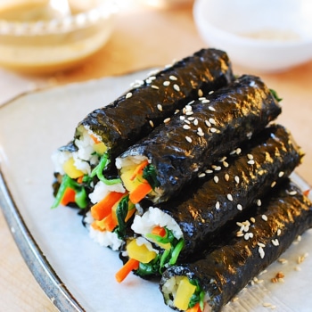 a pile of mini Korean seaweed rice rolls on a plate