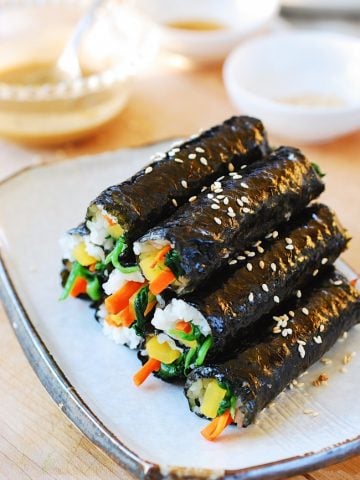 a pile of mini Korean seaweed rice rolls on a plate