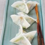 Three boiled zucchini dumplings in square or star shape on a green rectangle shape plate