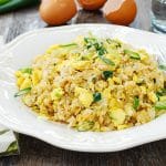 Egg fried rice with chopped green onion in a white plate