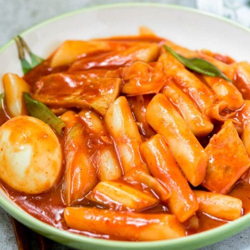 Red spicy Korean rice cake called tteokbokki in a large plate