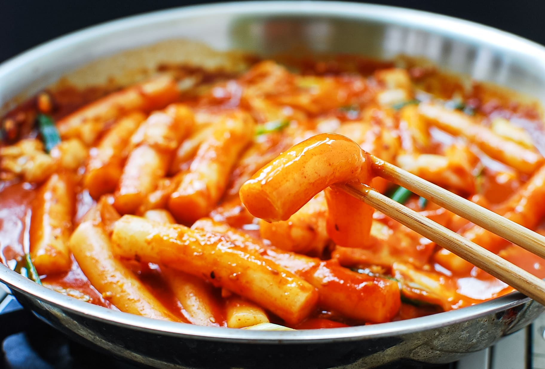 A side shot of tteokbokki--rice cakes in a spicy red sauce (a common Korean street food) 