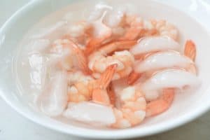 Cooling shrimp in ice water in a bowl