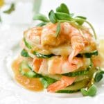 Shrimp salad stacked up on a plate with mustard dressing