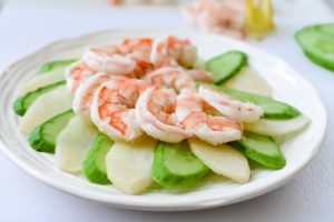 Arranging shrimp salad ingredients on a plate