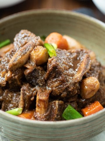 Korean braised beef short ribs in a large green bowl