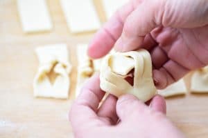 Twisting a dough piece to make a ribbon shape with hands