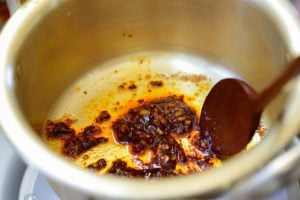 Stirring instant ramen seasoning mix with sesame oil and garlic