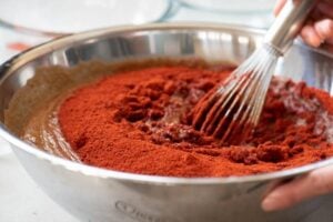 Stirring gochugaru (chili pepper powder) in malt liquid to make gochujang