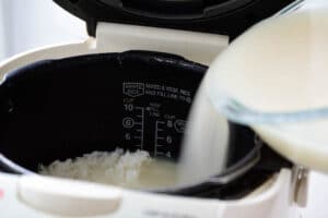 Pouring malt water into the rice cooker with rice