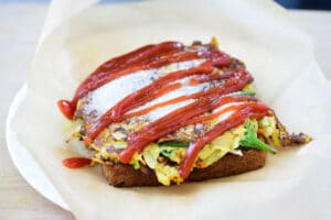 topping Korean egg toast with sugar and ketchup