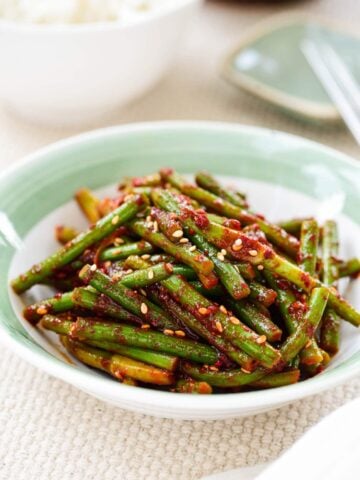 red spicy garlic scapes in a small bowl with light green trim