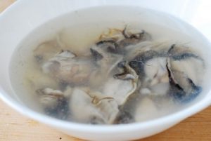 Oysters being rinsed in salt water for rice cake soup