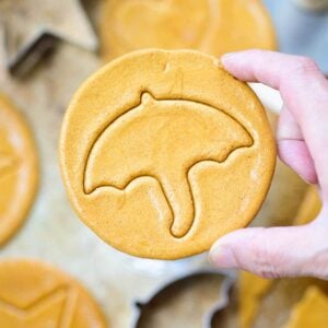 Holding up a round Korean honeycomb sugar candy with an umbrella imprint