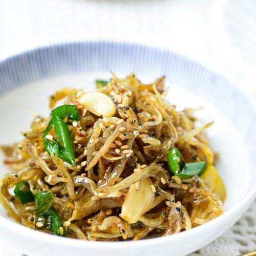 Stir-fried tiny dry anchovies in a small bowl with a blue trim