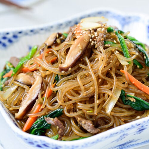 Stir-fried glass noodles with beef and vegetables in a square bowl